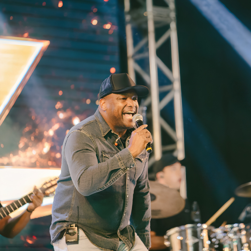 Carlucho ART cantando ao vivo no palco durante apresentação musical